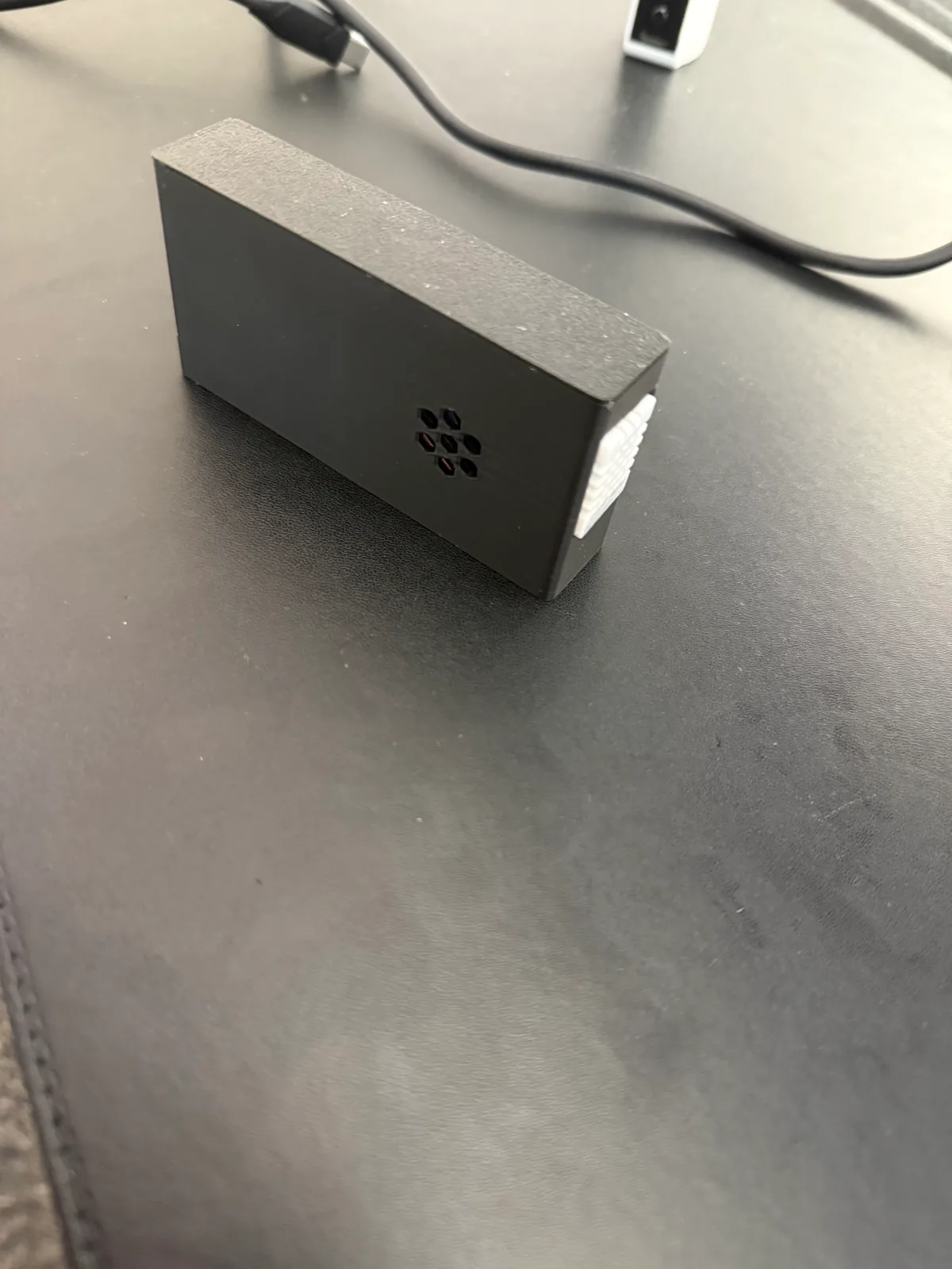 Boîtier AirSense imprimé en PLA, avec ouvertures hexagonales et capteur DHT22 visible sur le côté.